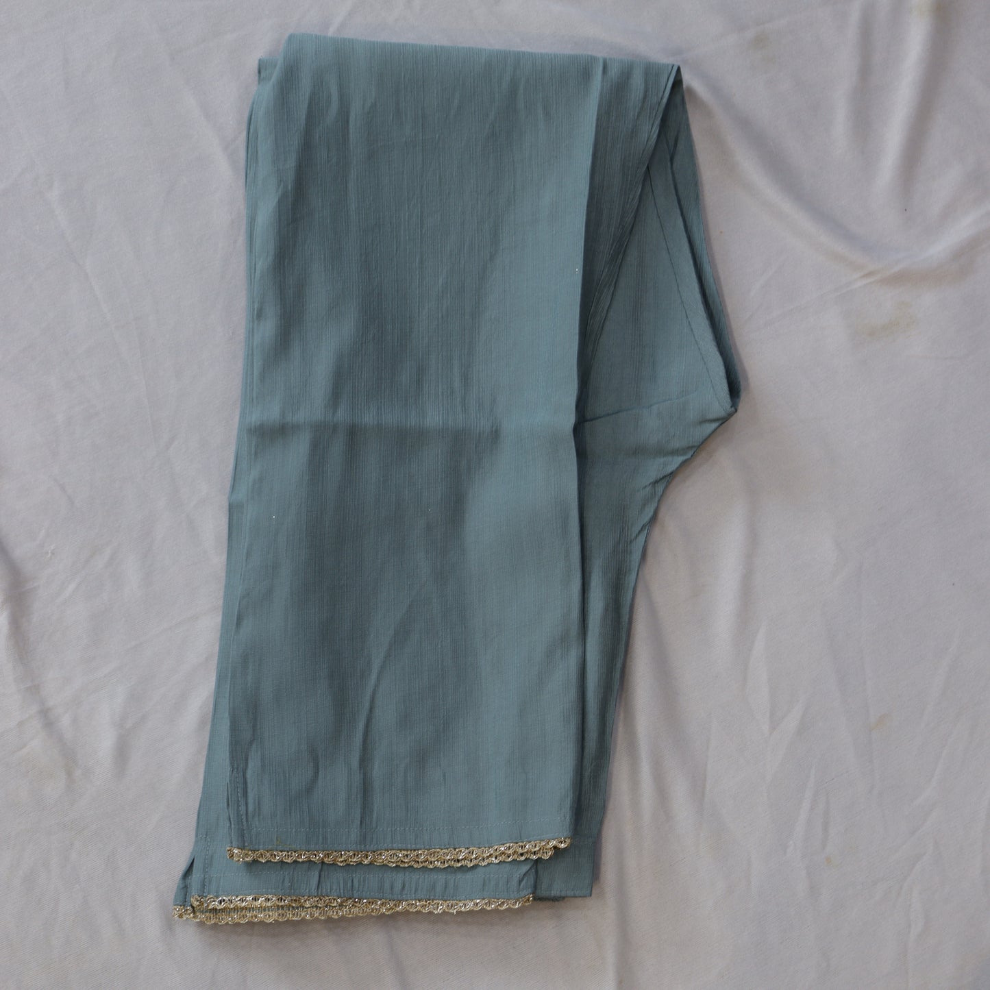 Teal embroidered fabric with a peacock design