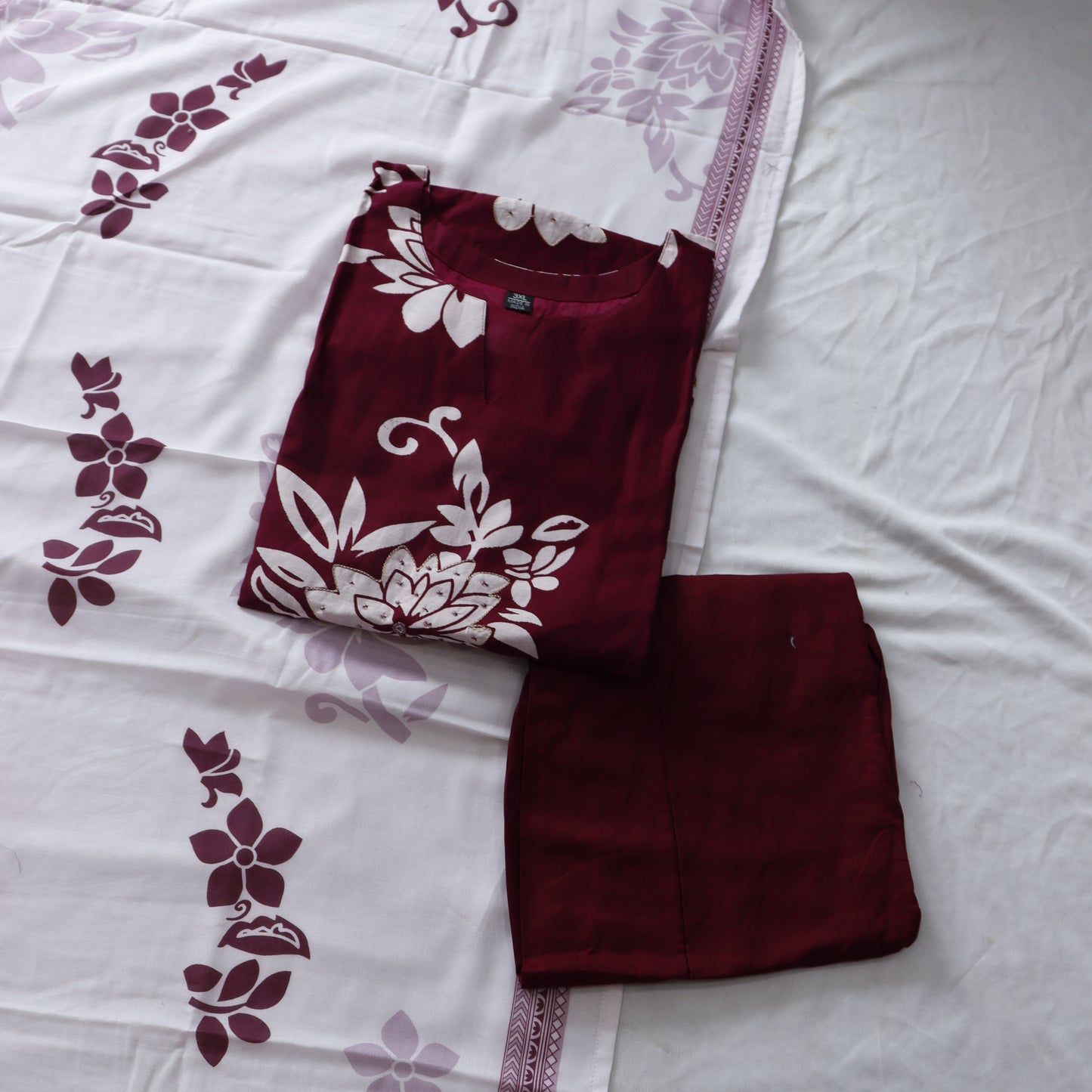 Maroon fabric with floral patterns on a white background