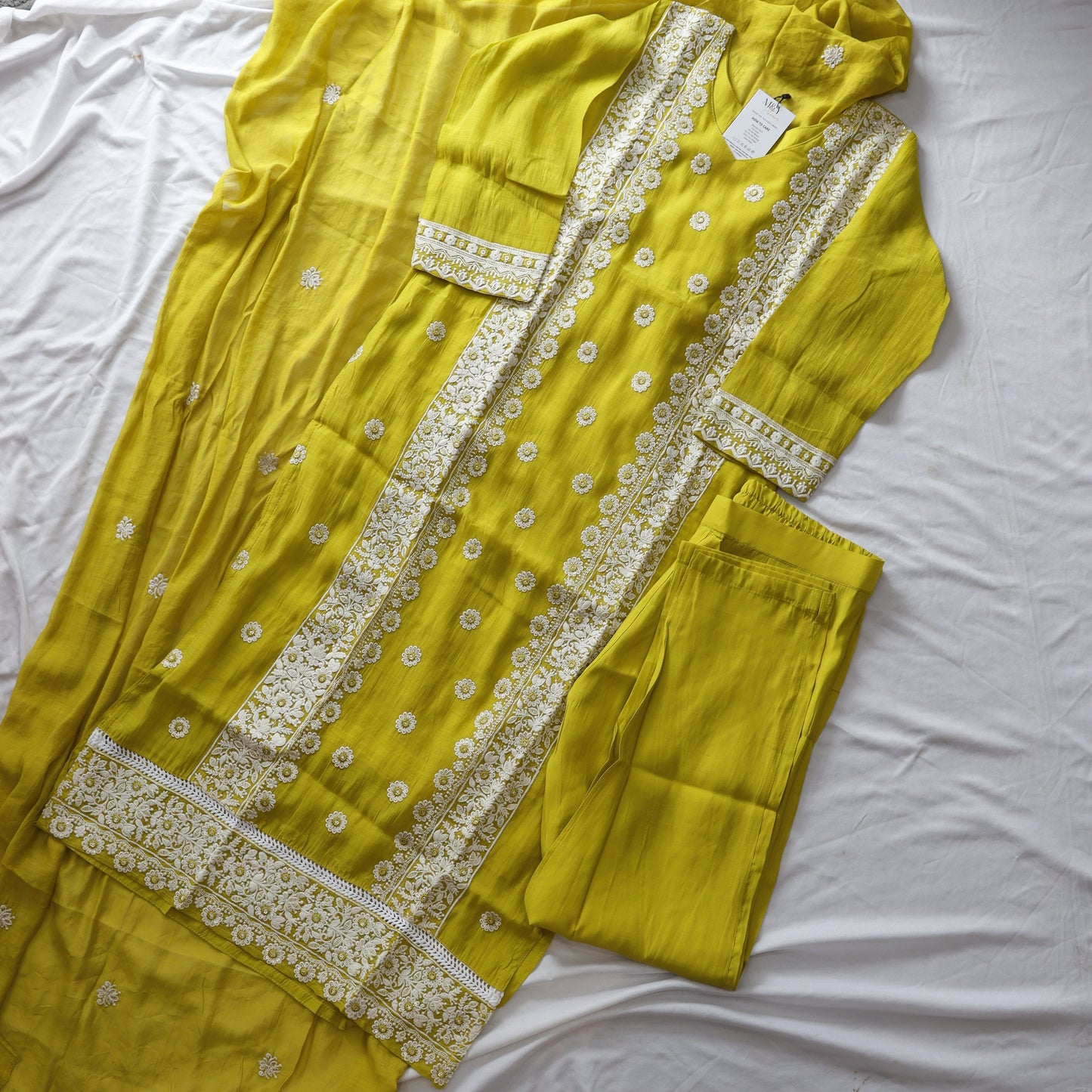 Yellow saree with white embroidery on a white background