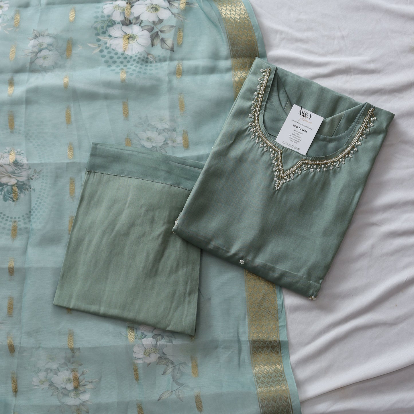 Green suit set with floral patterns on a white background