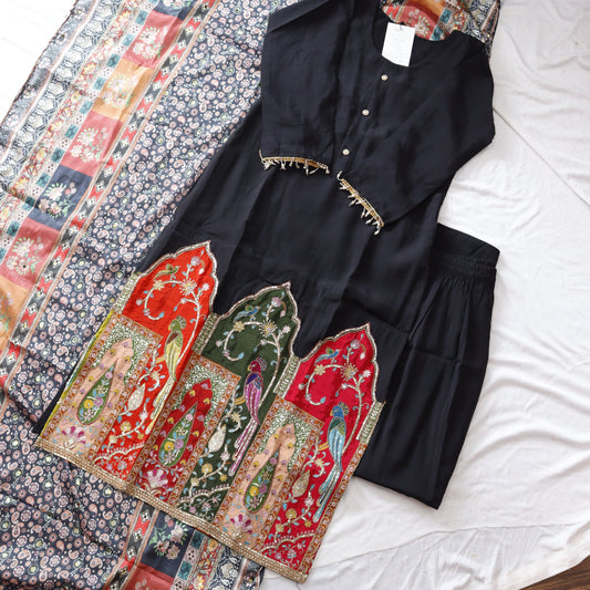 Black garment with floral patterns on a white surface