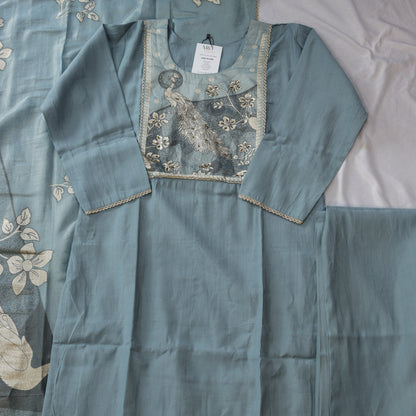Teal embroidered fabric with a peacock design