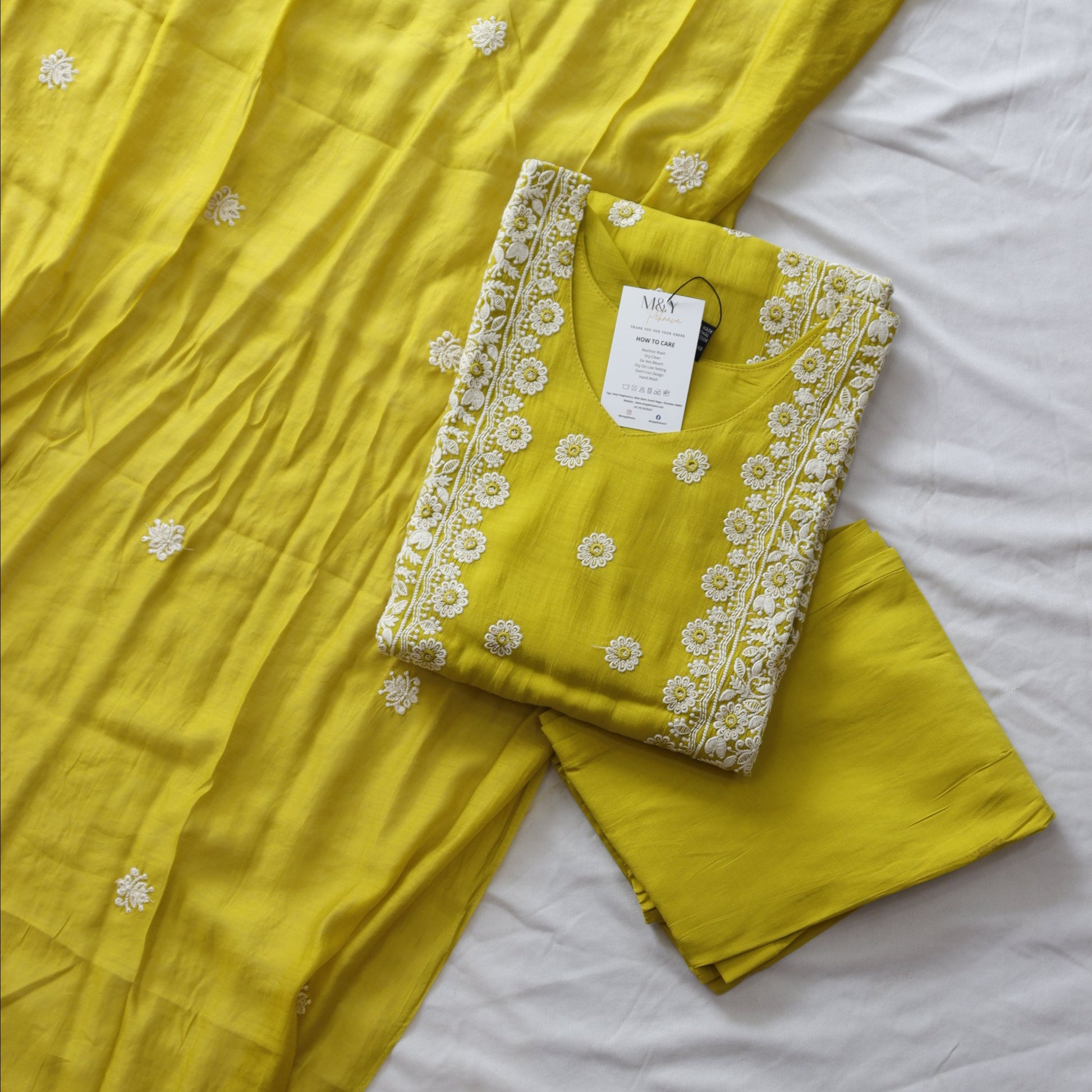 Yellow fabric with white embroidery on a white background